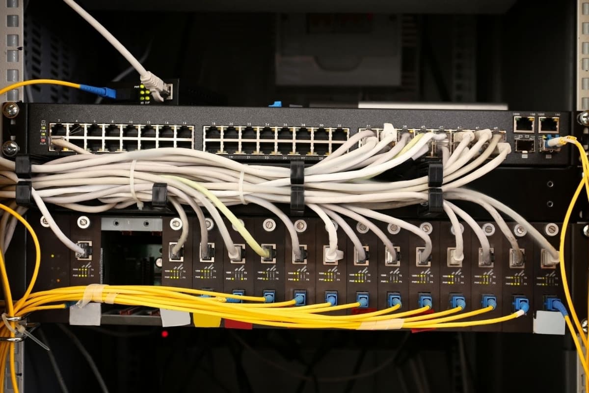 A network cabinet with a managed switch and patch panel, copper and fiber neatly dressed